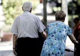 Una pareja de jubilados caminando por la calle.