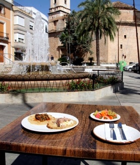 Imagen secundaria 2 - El Zorrilla a finales de los 80, un plato de 'arròs amb crosta' y unas cocas escaldadas una vista de la plaza de fondo.