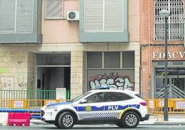 Un coche de la Policía Local de Valencia frente al edificio okupado en la avenida Constitución.