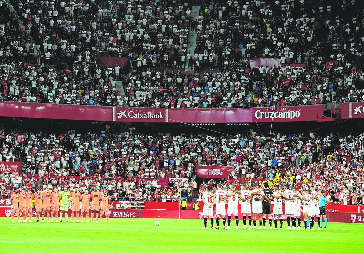 Los jugadores de ambos equipos, durante el minuto de silencio previo al partido.