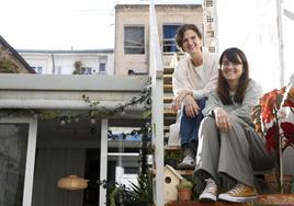 Beatriz y Marta Nogales, sentadas en las escaleras del patio de su estudio en Ruzafa, donde las plantas y algunos materiales están recogidos de la calle.