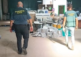 Dos guardias civiles junto a la droga y otros efectos intervenidos a la banda.