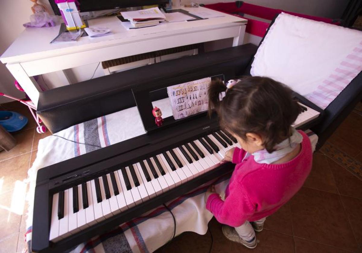 Una niña con Altas Capacidades toca un órgano o piano, en una imagen de archivo.