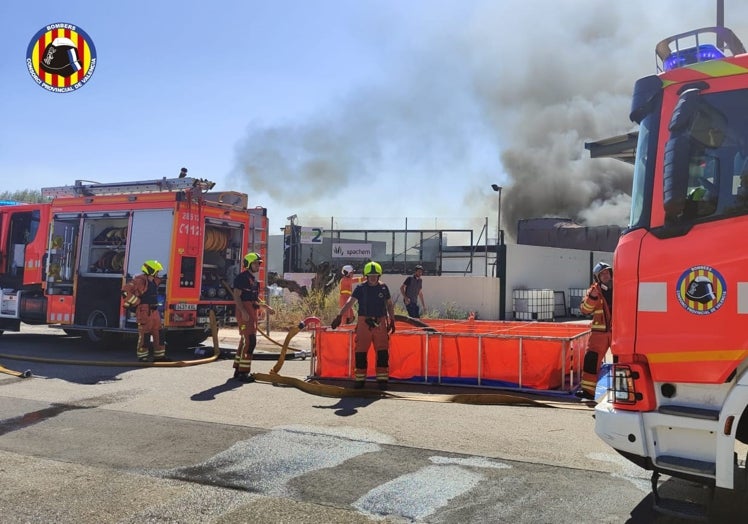 Imagen principal - Arriba, dotaciones de bomberos que han acudido al lugar; en el centro, la gran columna de humo como consecuencia del material quemado y, sobre estas líneas, estado en el que ha quedado la nave.