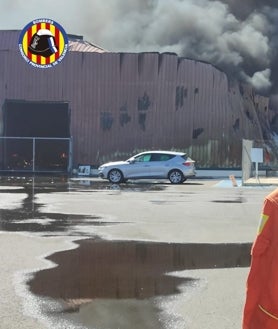 Imagen secundaria 2 - Arriba, dotaciones de bomberos que han acudido al lugar; en el centro, la gran columna de humo como consecuencia del material quemado y, sobre estas líneas, estado en el que ha quedado la nave.