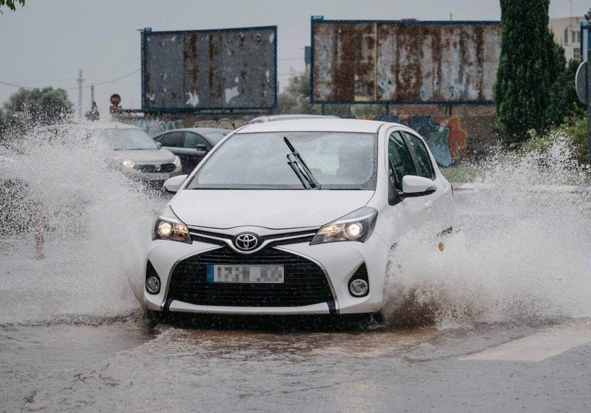 Un coche circula bajo el temporal que azota este fin de semana a la Comunitat.