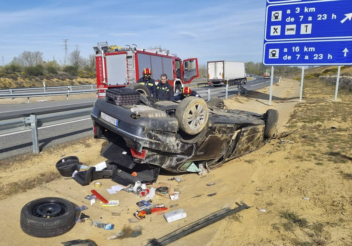 Un coche volcado en el arcén de una carretera.