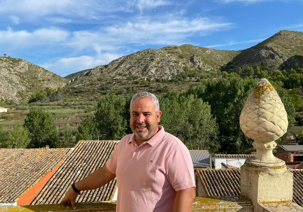 El actual alcalde de Pinet, Gonzalo Catalá, y al fondo la sierra que se quemó.