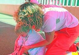 Una sanitaria enseña a un niño a hacer una Reanimación Cardiopulmonar.