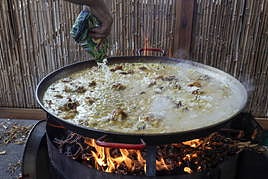 Un participante cocinando una paella en el concurso de Sueca.