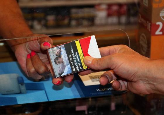 Una persona comprando tabaco en un estanco.