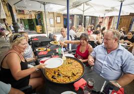 Turistas comiendo Paella en el restaurante El Rall.