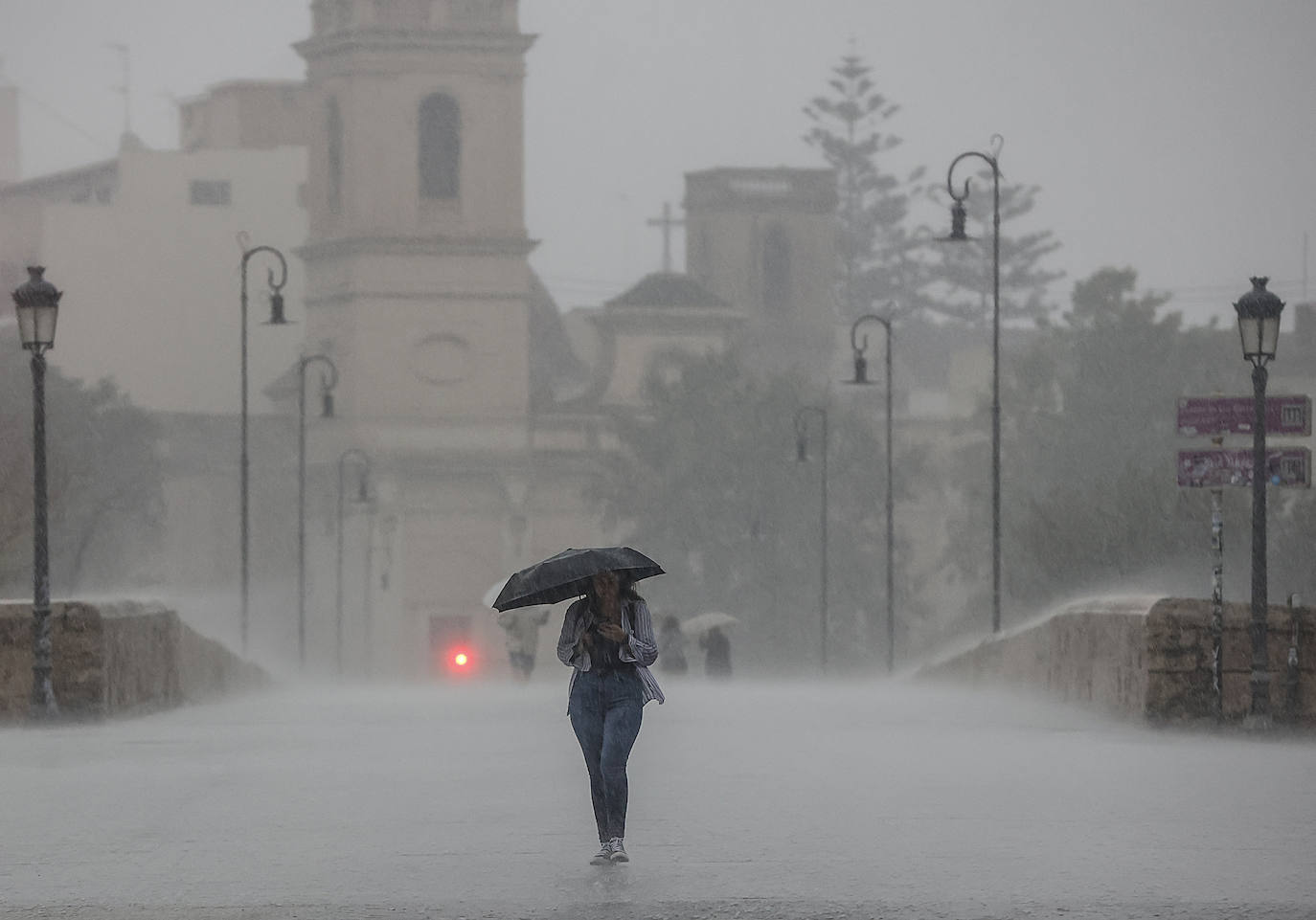 Una persona se refugia de la lluvia en una imagen de archivo.