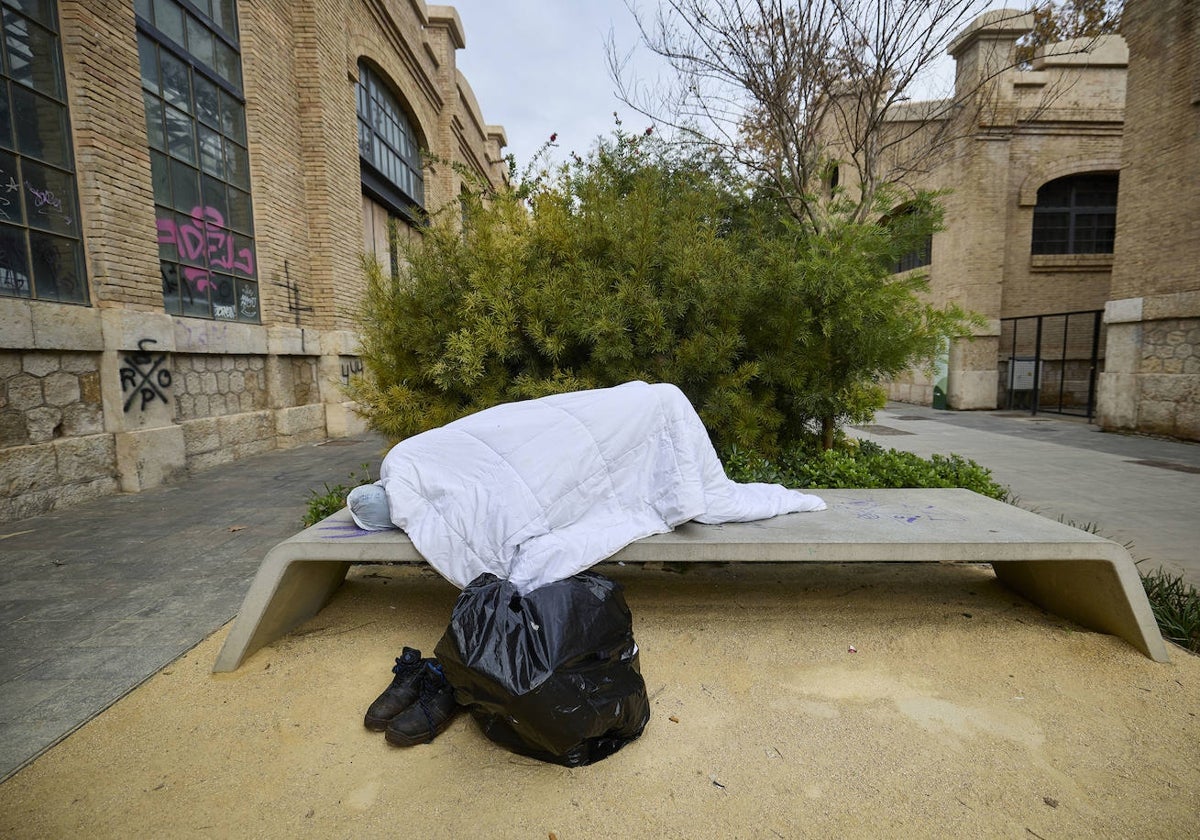 Una persona sin hogar, durmiendo en un banco de Valencia, en imagen de archivo.