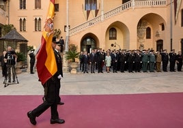 Agentes de la Policía Nacional de Gandia portan la bandera de España.