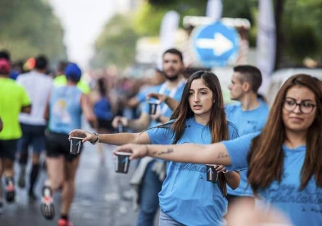 Voluntarios, listos para hidratar a los corredores.