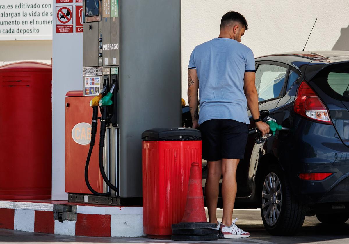 Un hombre echa gasolina a su vehículo en una estación de servicio.