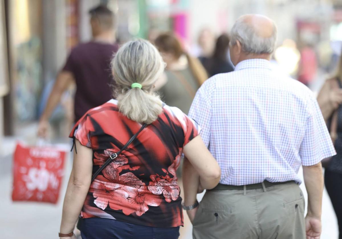 Un pareja de jubilados pasea del brazo