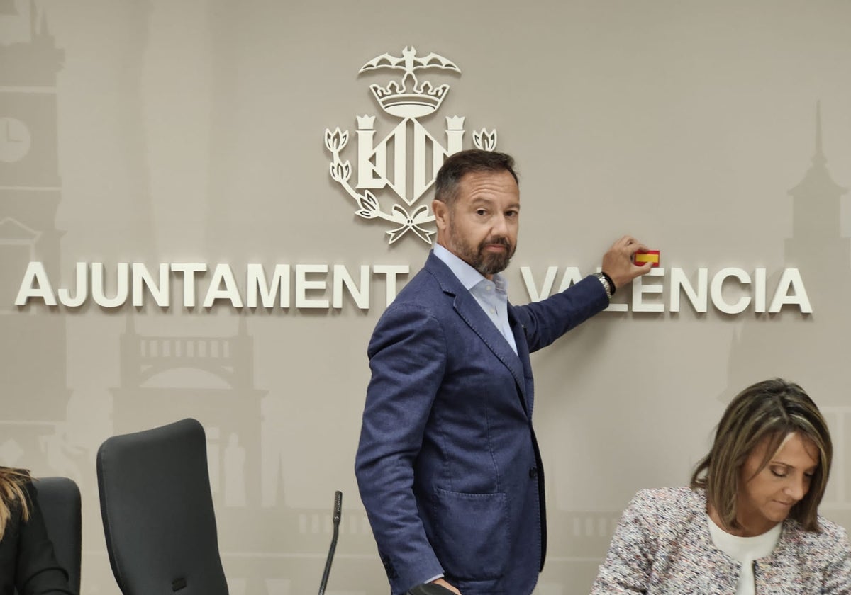 Badenas tapa con una bandera de España la tilde de València, en la sala de prensa municipal.