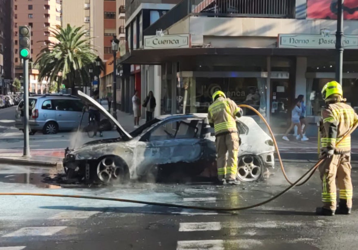 Los bomberos, durante las tareas de extinción del fuego en el vehículo.