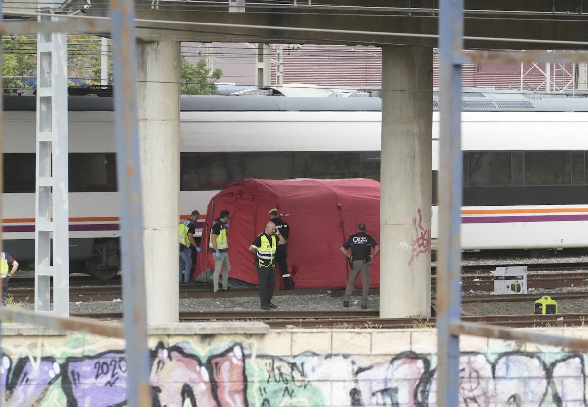 La policía junto al cadáver localizado entre dos trenes cerca de la estación de Santa Justa.