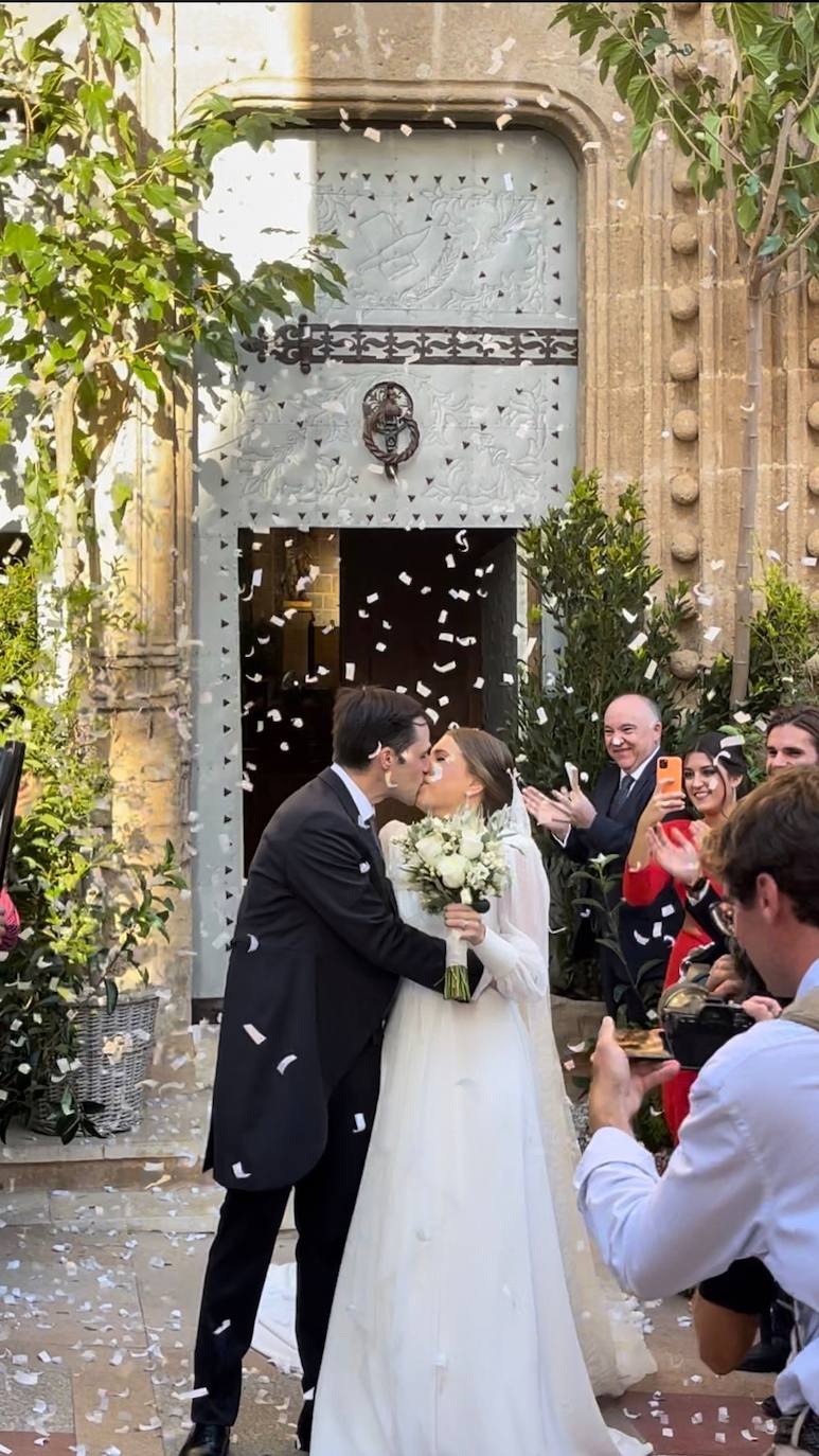 Eduardo y Sofía se besan bajo una lluvia de confeti blanco tras la boda.