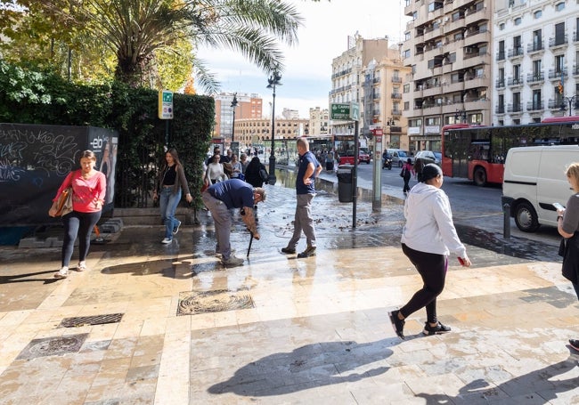 Operarios, accediendo la zona de paso de agua, en la calle Xàtiva de Valencia.