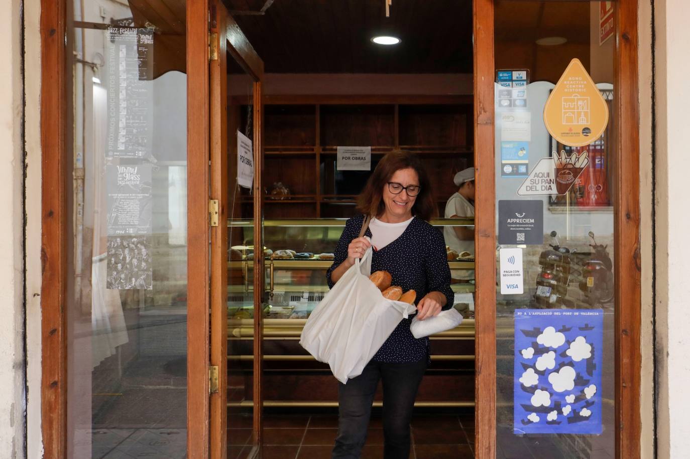 Una clienta sale del horno San Nicolás después de comprar el pan.