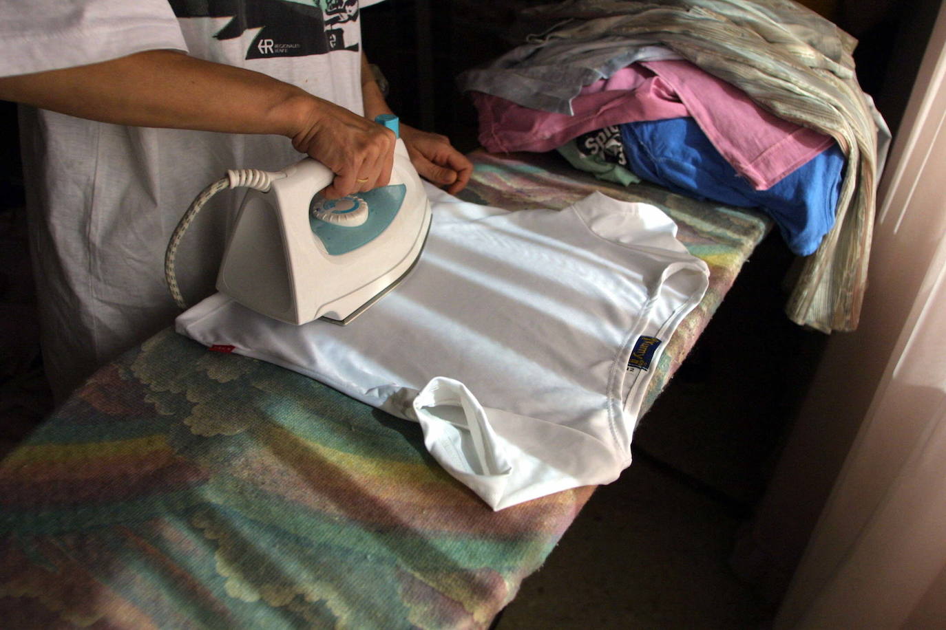 Una mujer plancha una camisa en una imagen de archivo.