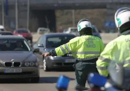 Un agente de la Guardia Civil de Tráfico detiene a los vehículos en un control de carretera.