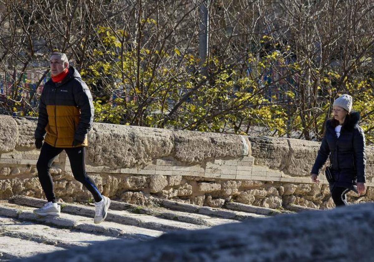 Personas caminan abrigadas en Valencia.