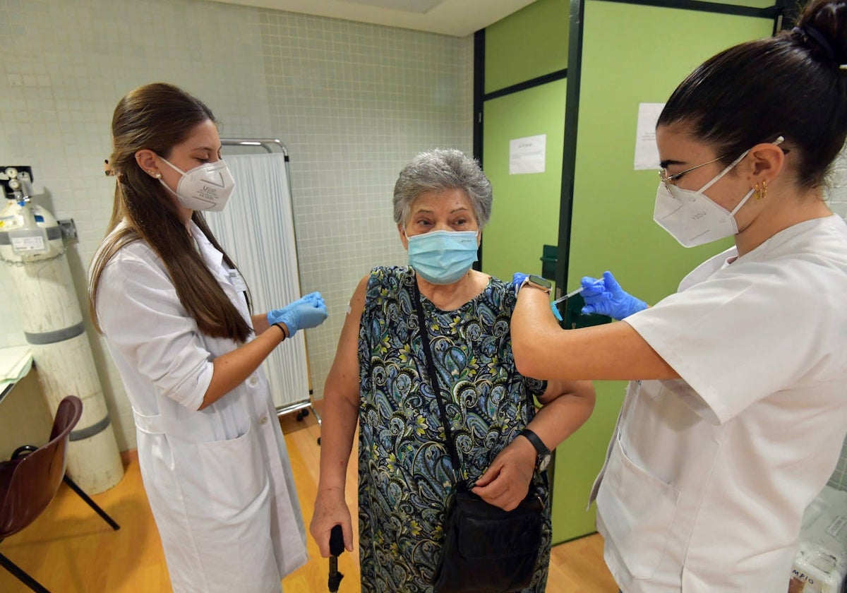 Dos enfermeras con una paciente en un centro de salud.