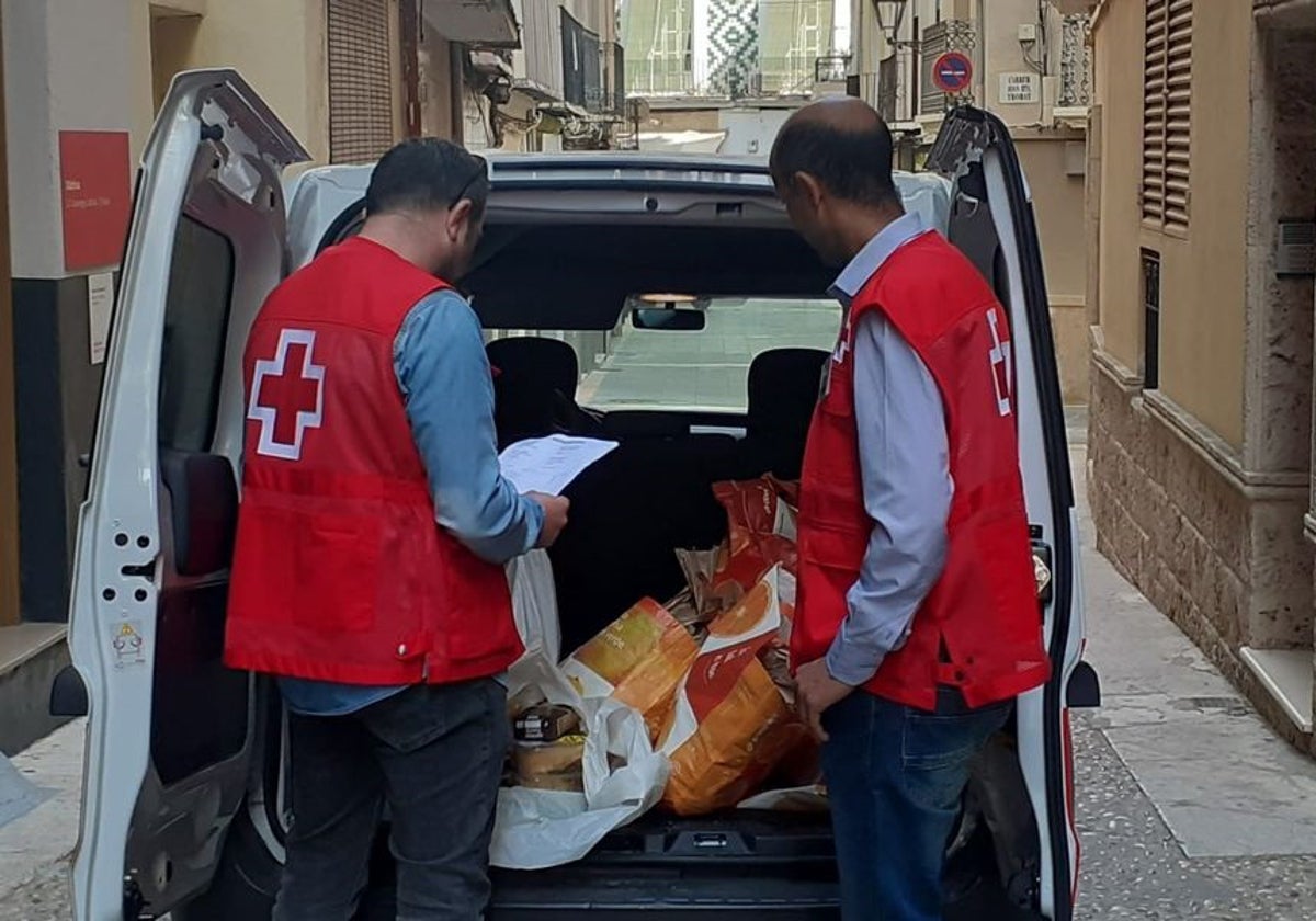 Dos voluntarios de Cruz Roja con alimentos para su reparto.