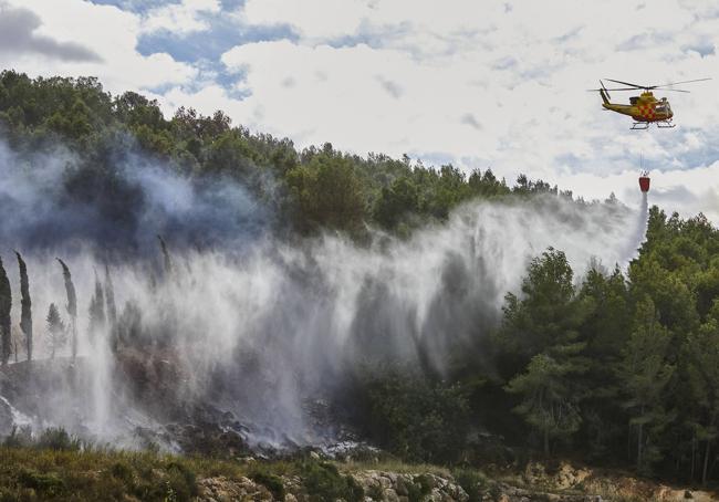 Un helicóptero combate este sábado el fuego del incendio de Montitxelvo, tras dos días sin aeronaves de extinción por el impedimento del viento.