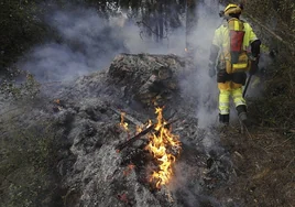 Un bombero de la Generalitat durante los trabajos de extinción del incendio en Montitxelvo, este sábado.