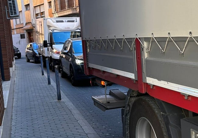 Camiones y coches en una de las calles estrechas próximas a la Plaça Major por donde se ha desviado el tráfico.