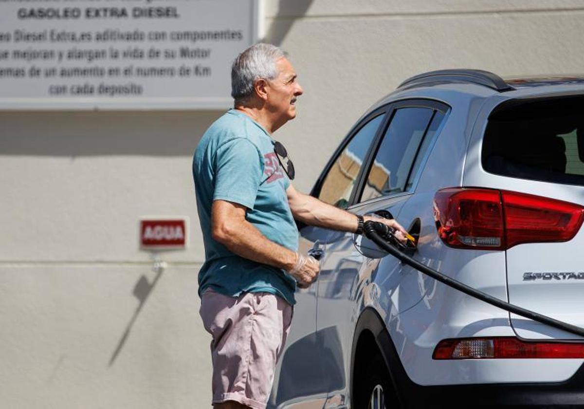 Un hombre pone gasolina.