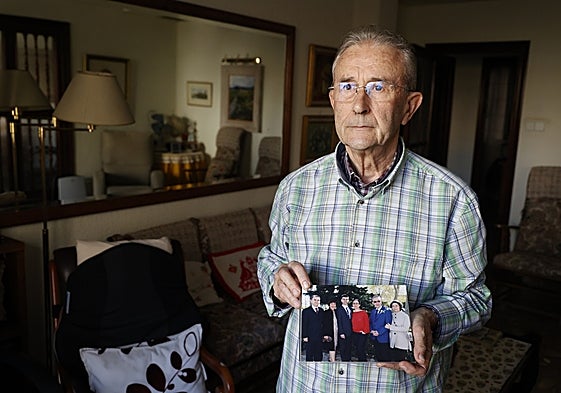Alejandro Mendoza, en su domicilio de Valencia, muestra una foto familiar con su esposa.