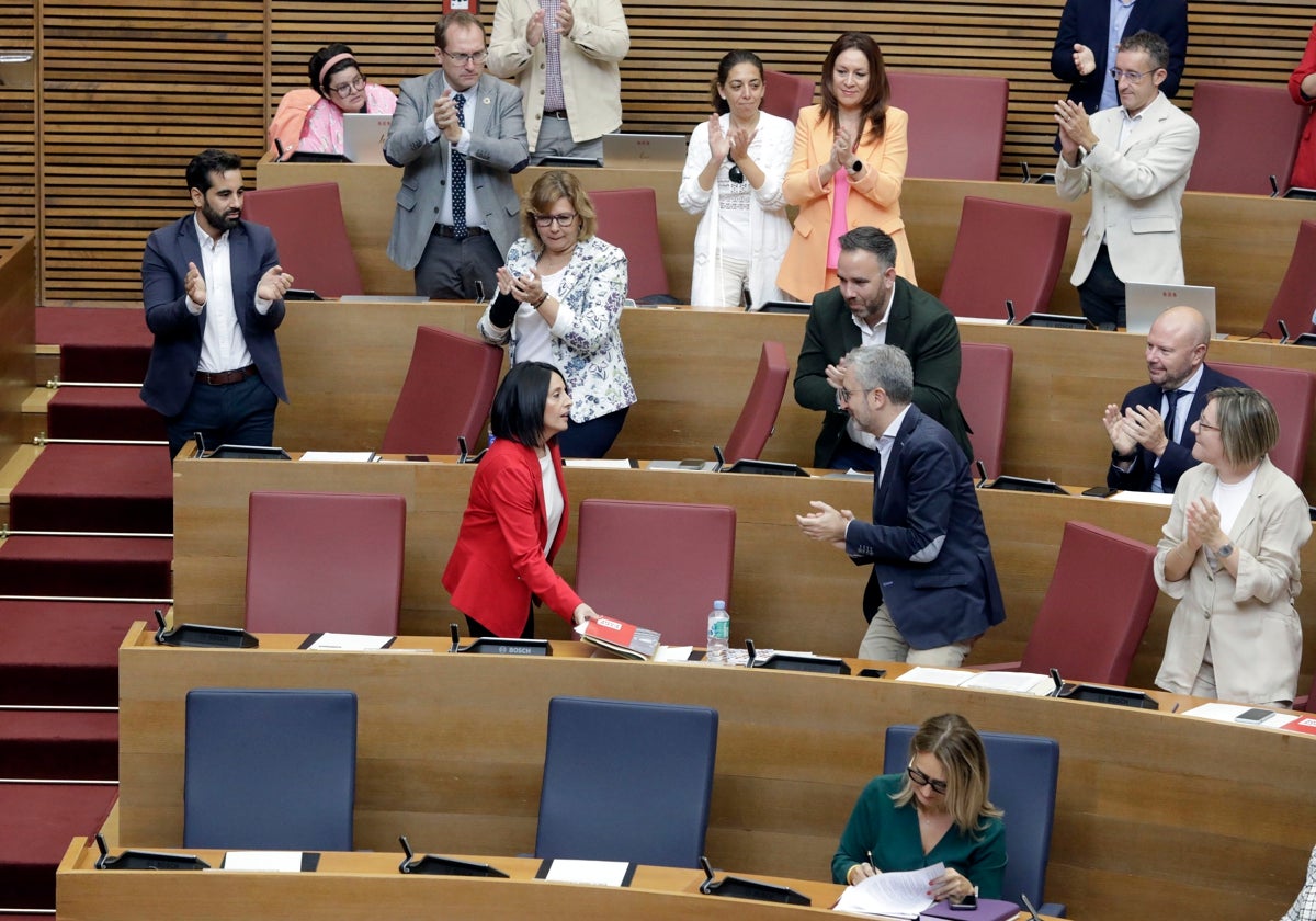 Rebeca Torró regresa a su escaño tras pasar por la butaca vacía de Puig.