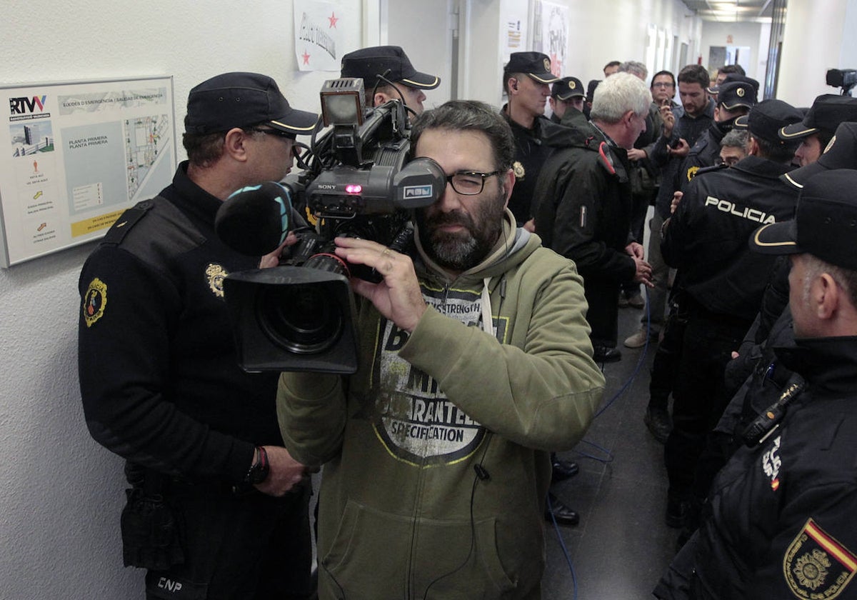 Un cámara de Canal 9, Vicent Santapau, graba en los instantes finales de la cadena autonómica, rodeado de policías.