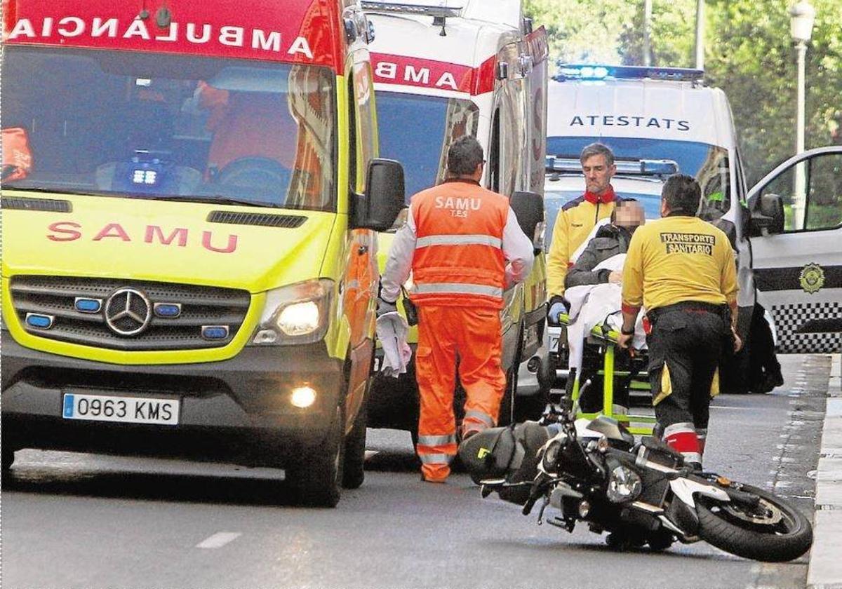 Ambulancias y policías locales junto a un motorista accidentado en Valencia, en una imagen de archivo.