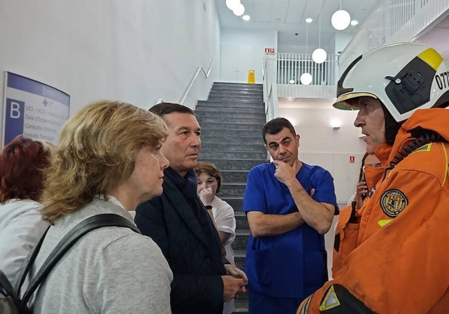 El conseller de Sanidad, Marciano Gómez, conversa con un mando de bomberos y responsables del hospital.