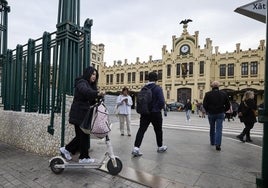 Una usuaria de patinete entra a la estación del Norte, este martes.