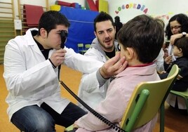 Ópticos realizan pruebas visuales a unos niños.
