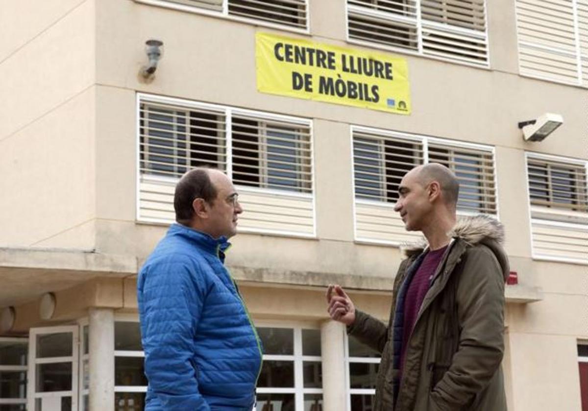 Dos miembros de la comunidad educativa del instituto dialogan junto al centro.