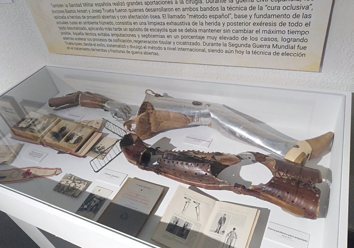 Imagen principal - Prótesis, material médico y manuales de intervención. Abajo, una maqueta del carro hipomóvil de 1850 para evacuar heridos y una fotografía con niños para destacar la labor de las enfermeras. 