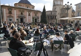 Terraza repleta de gente en la plaza de la Virgen.