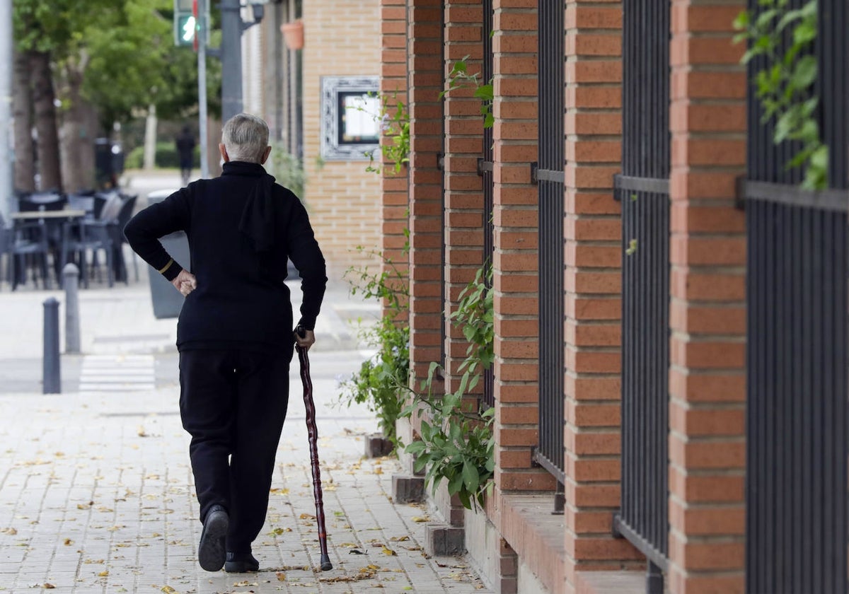 Una persona mayor pasea por una calle de Valencia.