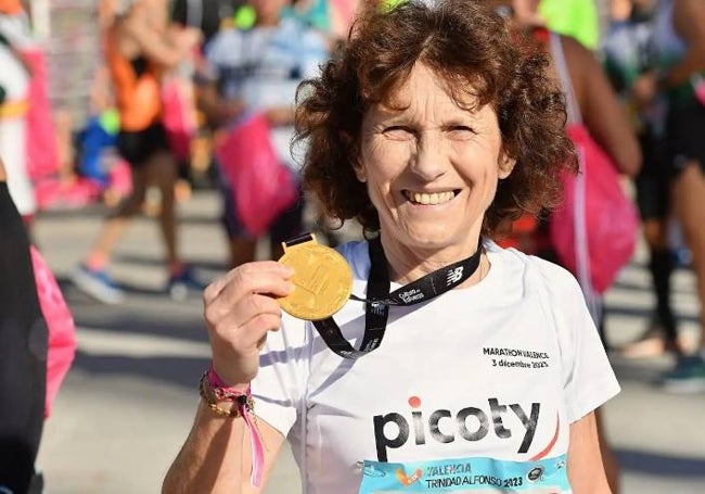 Una participante en el Maratón de Valencia muestra orgullosa su medalla.