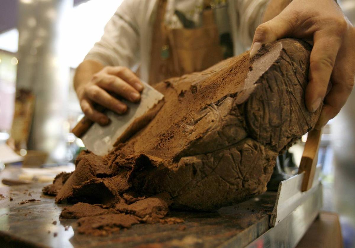 Un repostero trabaja un trozo de cacao durante una exhibición realizada dentro del Salón del Chocolate en Madrid.